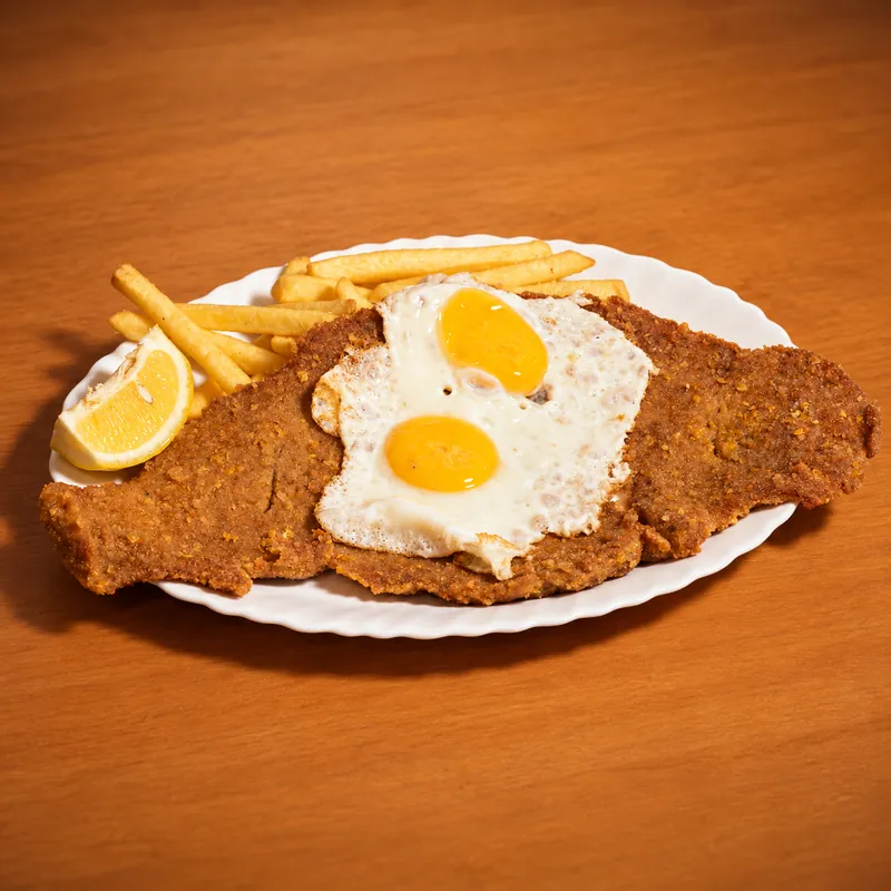 Milanesa di Salta Food con patatine fritte e due uova fritte · Milanesa a caballo (con le uova)