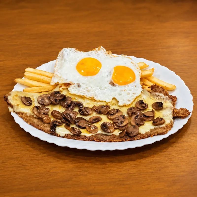 Milanesa di Salta Food con patatine fritte e due uova fritte · Milanesa ai funghi