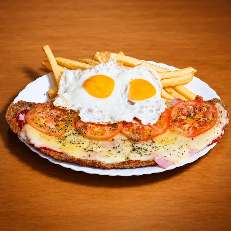 Milanesa napolitana amb dos ous ferrats i patates fregides